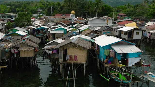 Aerial view boats beside houses located by the water in Zamboanga raised on stilts. Mindanao, Philippines.