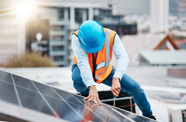 Engineer man, screwdriver and solar panel on roof for maintenance, industry and construction in city. Technician, tools and photovoltaic system with helmet, development and renewable energy in cbd © Malik/peopleimages.com
