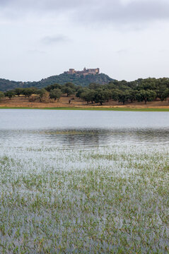 Imagen vertical del embase Pe&ntilde;a del &Aacute;guila, con el castillo de Azagala al fondo en un d&iacute;a nublado.