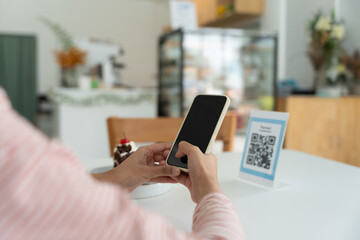 Woman use smartphone to scan QR code for order menu in cafe restaurant with a digital delivery. Choose menu and order accumulate discount. E wallet, technology, pay online, credit card, bank app.