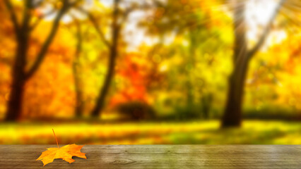 sunlight in an idyllic blurred autumn park with empty wooden table in foreground, colorful october...