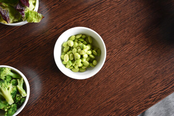 Soybeans in a small white bowl on a wooden table