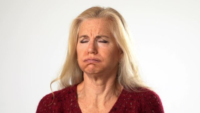 Closeup portrait of angry upset frustrated attractive mature senior woman with blond hair isolated on solid white background.