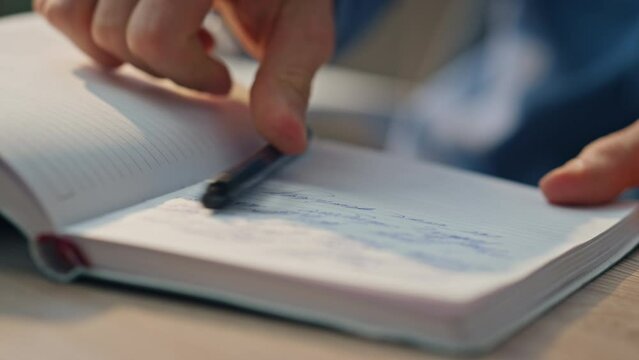 Closeup businessman hands writing notes at desk. Man preparing schedule notebook