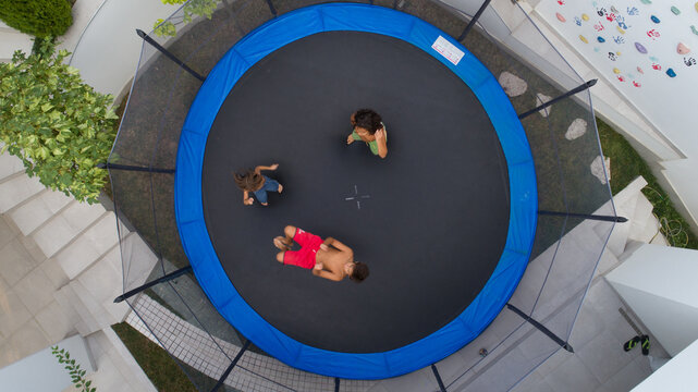 Children playing on trampoline aerial view together