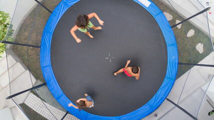 Children playing on trampoline aerial view together