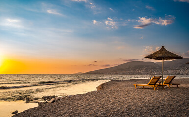 Sarande beach during sunset. Bistrica Beach with view at Sarande city. beautiful evening sky - obrazy, fototapety, plakaty