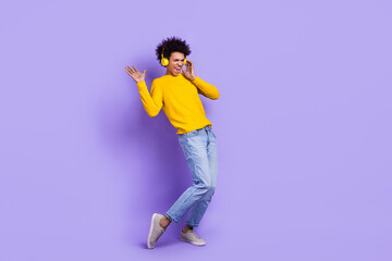 Fototapeta na wymiar Full body size view cadre of careless freedom young guy dancing touch wireless earphones crazy mood isolated on purple color background