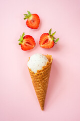 Strawberry ice cream. Ice cream cone top view on pink.