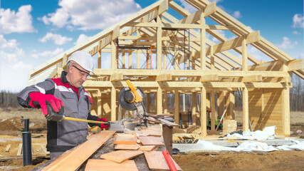 Man is building house. Builder near wooden boards. Construction of wooden house. Guy uses...