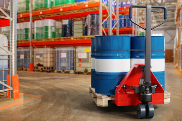 Pallet jack with barrels. Goods storage area. Pallet jack inside warehouse. Hydraulic cargo...