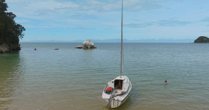 Aerial: yacht moored on beach and Split Apple Rock, Kaiteriteri, New Zealand