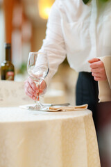 Preparing tableware in restaurant interior by waiter