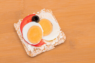 Rice Cake Sandwich with Tomato, Eggs and Olives on Bamboo Cutting Board. Easy Breakfast. Diet Food....