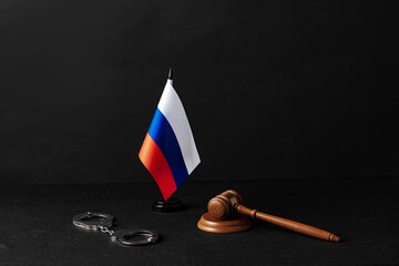 Russia flag with judge mallet and handcuffs on black background