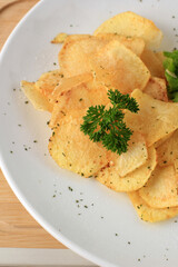 Potato Chips on White Plate with Fresh Parsley