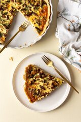 Portion of pie on a plate, homemade quiche with seasonal forest mushrooms Chanterelles on a yellow...