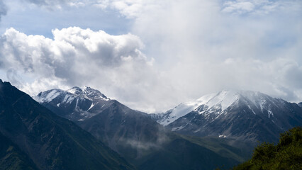 cloudy weather in a mountain gorge. clouds over mountain peaks