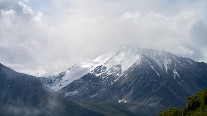 Fototapeta premium cloudy weather in a mountain gorge. clouds over mountain peaks