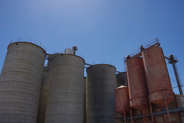Big agricultural silos under blue sky