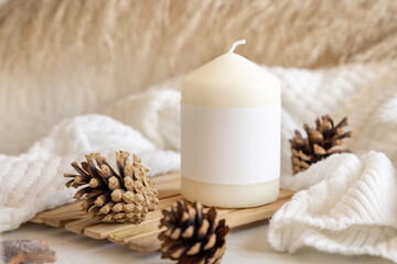 Candle with blank label near natural wooden decorations, Close up, copy space, mock up