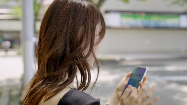 屋外でスマホを使ってSNSをチェックする女性