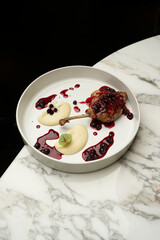 Baked duck leg with mashed potatoes and berry sauce