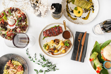 View from above of several plates of food. Variety of different dishes. 