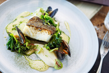 Cod fillet with cauliflower cream, asparagus, clam-wine sauce and mussles. Delicious seafood fish...