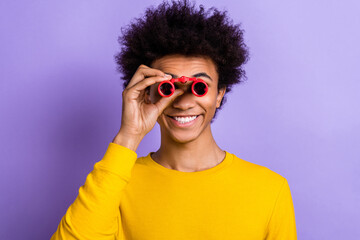 Photo funny young guy chevelure wear shirt holding antique retro red binoculars spying watch theater isolated on violet color background