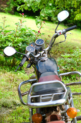 The motorcycle stands in the summer yard outside the city