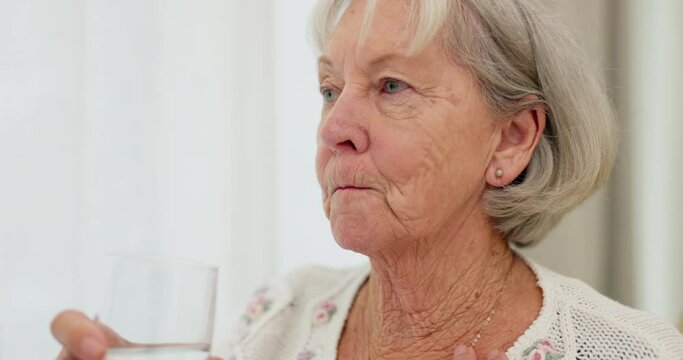 Health, thirsty and mature woman drinking water for hydration and liquid diet detox at home. Wellness, fresh and calm elderly female person enjoying glass of cold drink in modern retirement house.