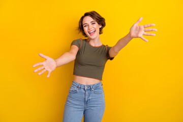 Photo of shiny excited lady wear khaki t-shirt open arms ready hug you isolated yellow color...