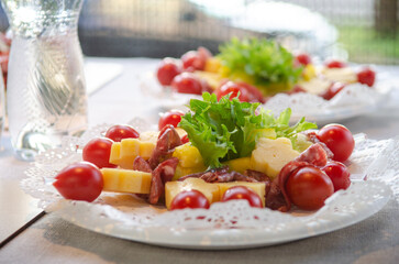 Catering in the evening, small sausage cheese and tomato sandwiches on plates in the sunlight