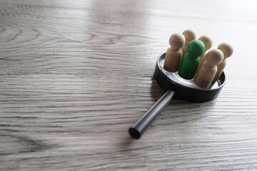 Wooden dolls on top of magnifying glass. Human resources, target market and audience, focus group concept