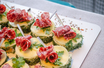 Catering in the evening, small sausage and cheese sandwiches on plates in the sunlight