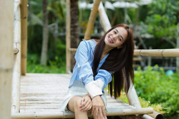 Beautiful young woman's day Asian male hair guard Smiling happily on the bamboo path After coming to relax on the weekend