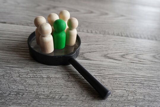 Wooden Dolls On Top Of Magnifying Glass. Human Resources, Target Market And Audience, Focus Group Concept