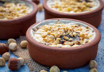 Baked rice pudding turkish milky dessert sutlac in earthenware casserole with hazelnuts