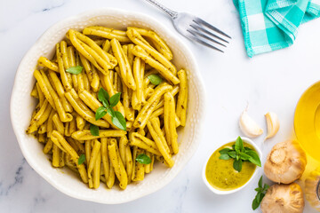 Casarecce pasta with cilantro pesto sauce on a grey background, top view. Delicious vegetarian lunch.