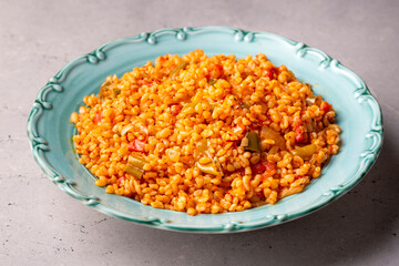 Traditional turkish bulgur pilaf with tomato sause in plate (Turkish name; meyhane pilavi)