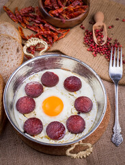 Fried sausage with egg in copper pan turkish meal