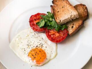 Fried slices of delicious eggs next to a slice of toast.