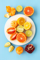 Layout of citrus fruits on white plate top view
