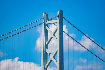 Fototapeta premium 明石海峡大橋の主塔の上部をクローズアップした写真。晴天を背景にとても美しい姿をしています。