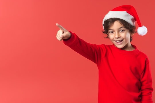Little kid with christmas hat pointing to blank space on red background. Generative AI