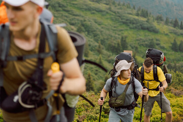 portraits of a group of friends climbing from the foot of the mountain to its peak, selective focus