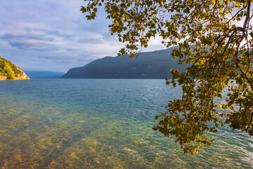 Beautiful sunset light reflection in Bourget lake clear water,  Savoie, France. Jura mountains at...