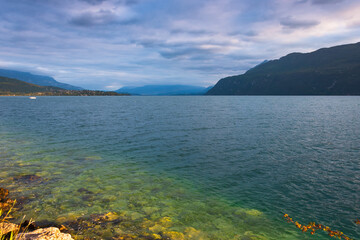 Sunset landscape of Bourget lake with boat in Savoie, France. Light reflection in clear water....
