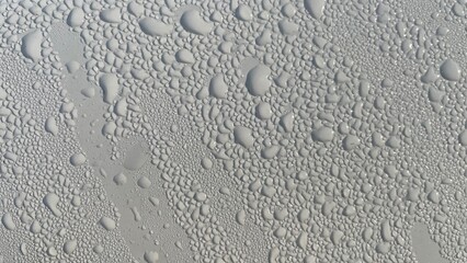 Dewdrops fall on the metal surface, creating a beautiful water bubble texture